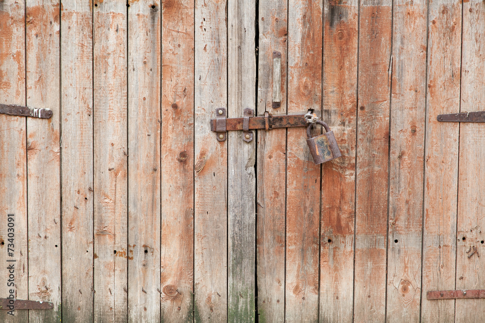 Old wooden door locked with padlock Old wooden door locked with padlock