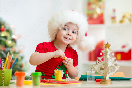 kid in Santa hat making chr...