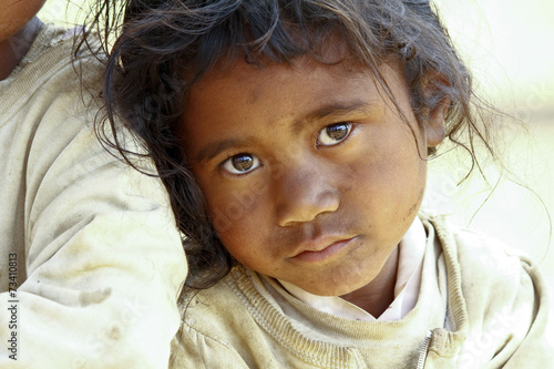 Poverty, portrait of a poor little African girl lost in deep tho photo