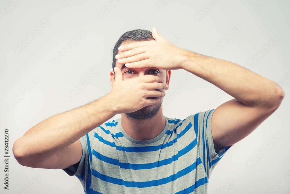 Young Caucasian man hiding his face with hand Young Caucasian man hiding his face with hand