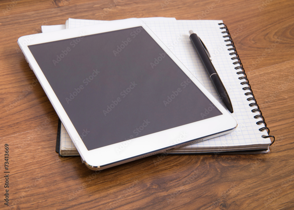 tablet with papers and pen on a wooden desk tablet with papers and pen on a wooden desk
