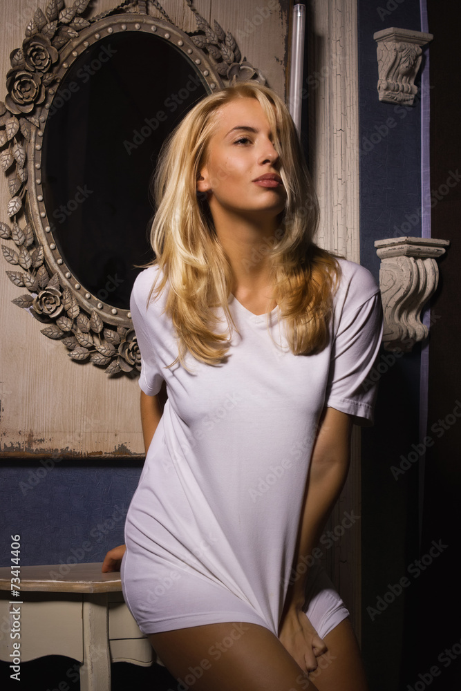 Hot woman in white t-shirt posing in gothic interior Stock Photo