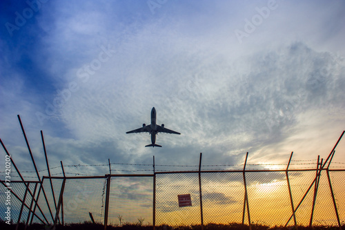 An airplane flying over barbed wire fence in Phuket airport