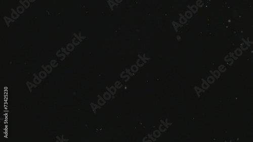 Small pieces of dust on black. HD.
