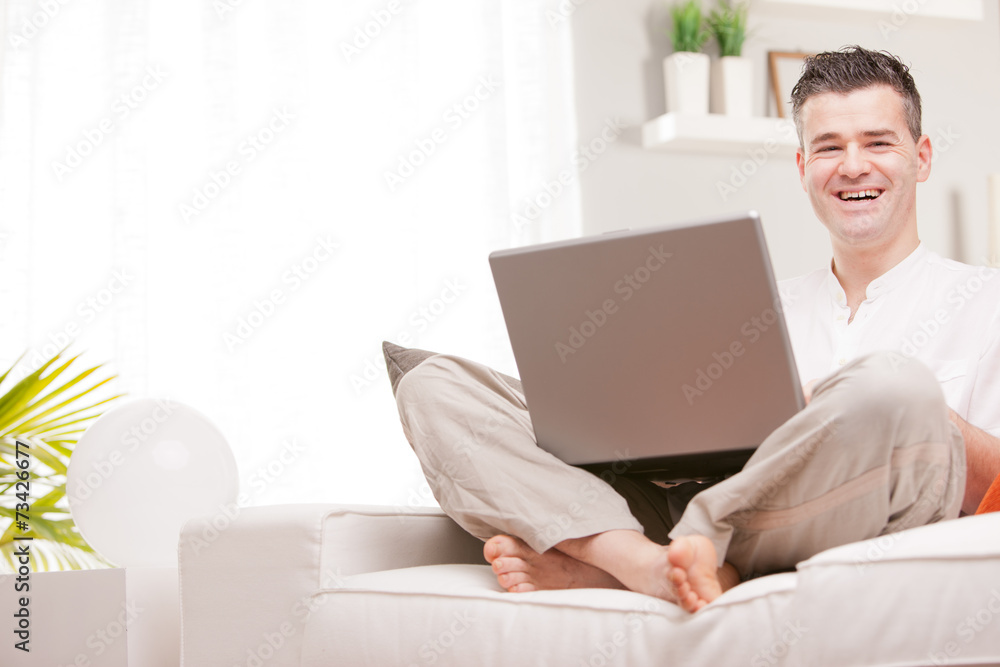 man smiling to camera using a notebook man smiling to camera using a notebook