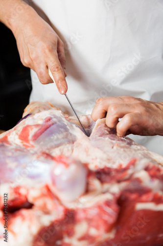 Midsection Of Butcher Cutting Meat