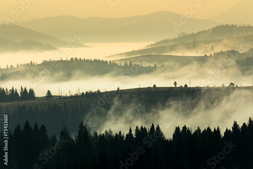 cold fog on hot sunrise in mountains