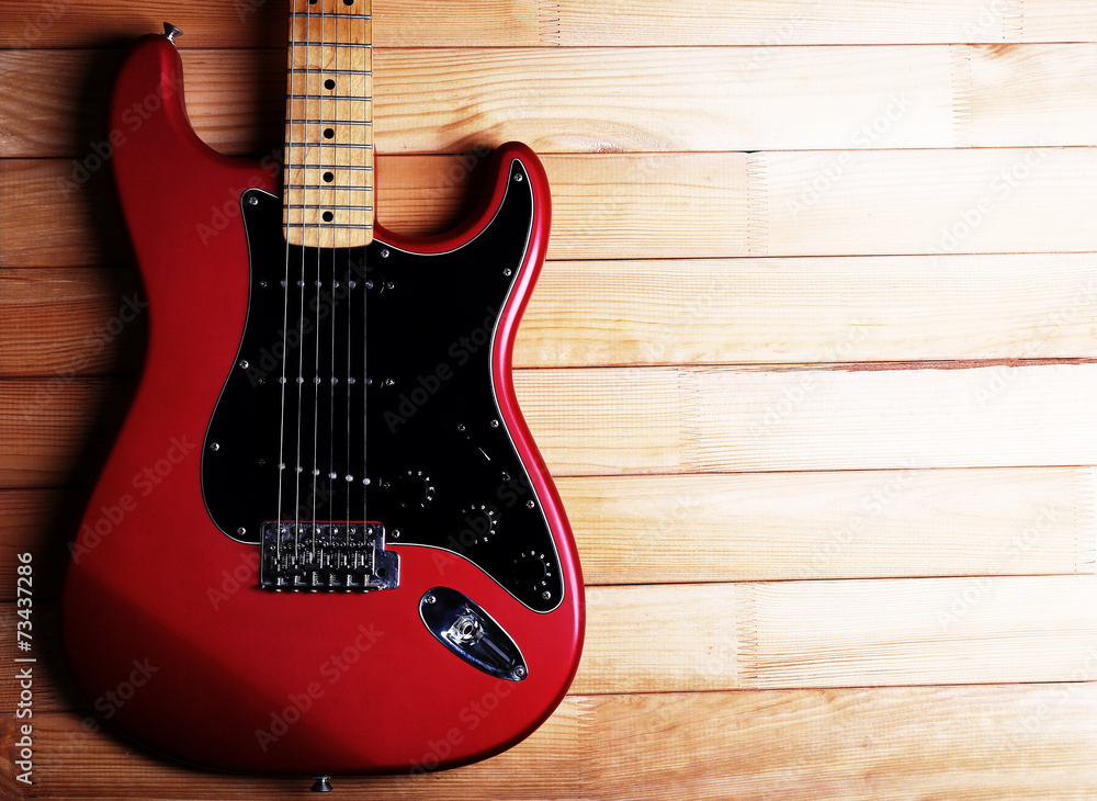 Obraz premium Red guitar on wooden background