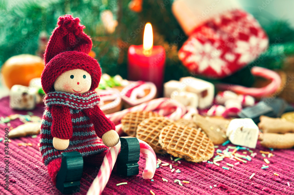 Close-up christmas wooden doll with sweets.
