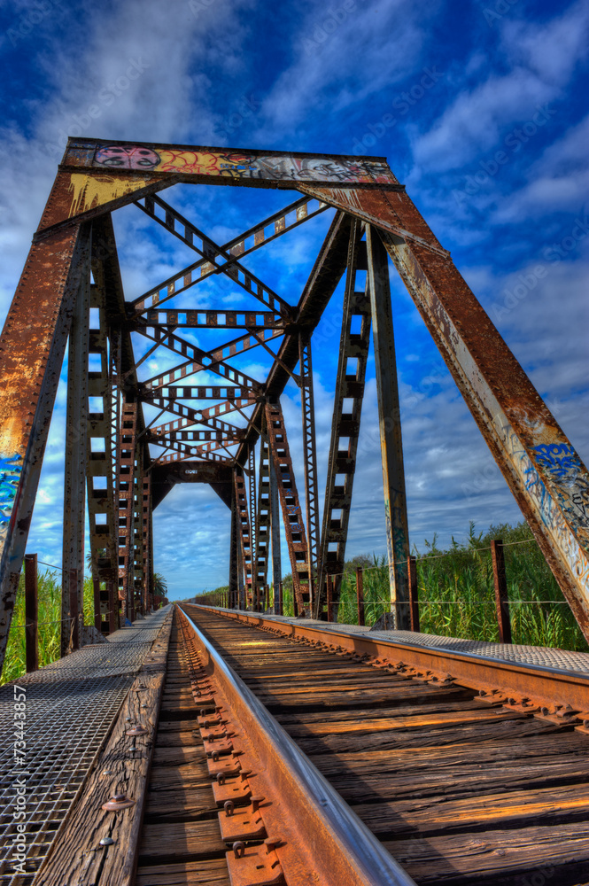 Weathered train trestle shows rust and graffiti Weathered train trestle shows rust and graffiti