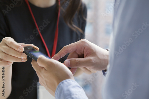 Woman looking into a man of mobile phone