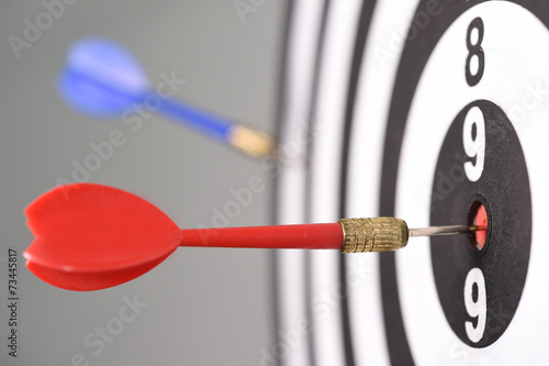 Dartboard with darts on gray background.