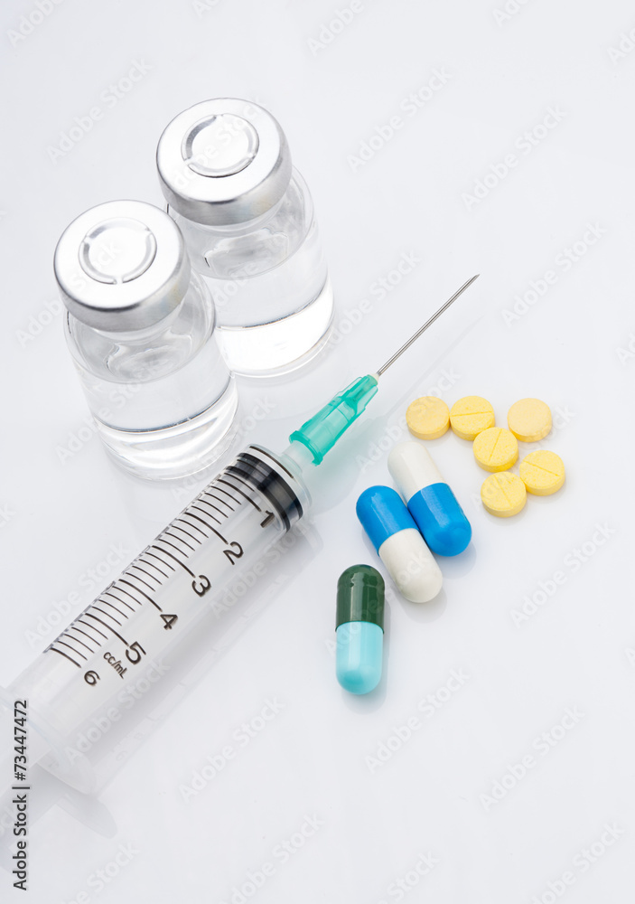 Syringe with medical ampoule and tablets on white background Syringe with medical ampoule and tablets on white background