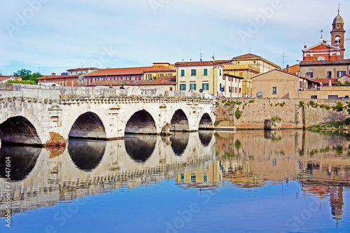 Historical roman Tiberius bridge over river in Rimini, Italy photo