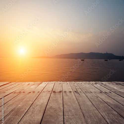 plank board with lake in sunset as background