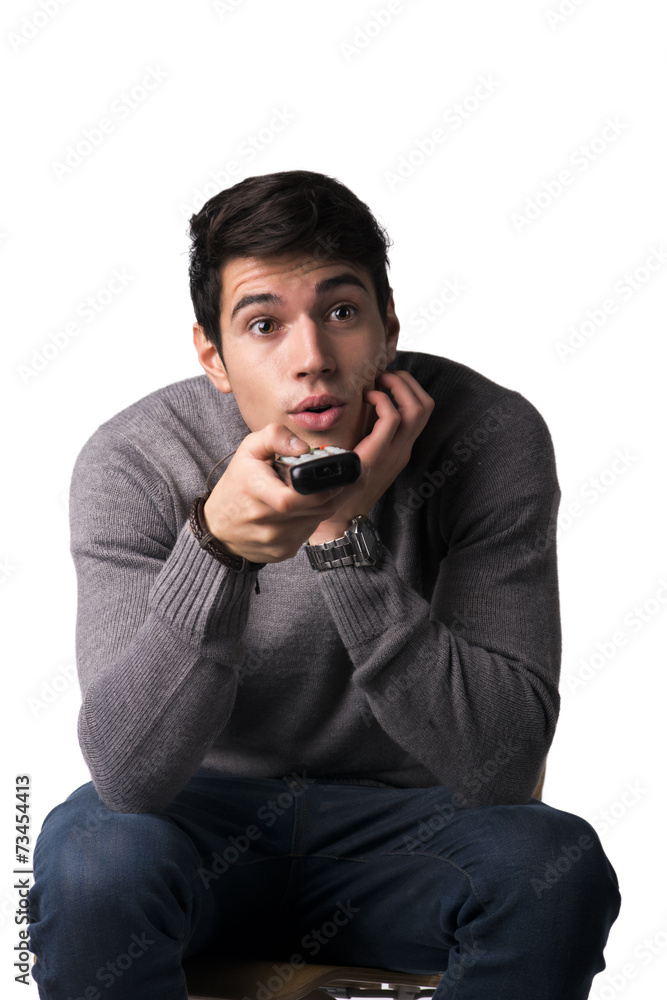Young man holding remote control and changing TV channels Young man holding remote control and changing TV channels