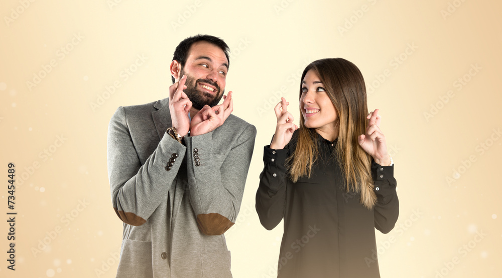 Couple with their fingers crossing over gloss background Couple with their fingers crossing over gloss background