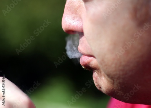 smoker throws out the smoke from his mouth