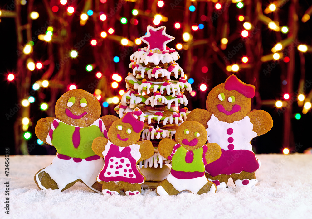 Gingerbread cookie family in front of christmas tree Gingerbread cookie family in front of christmas tree
