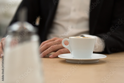 Zuckerstreuer auf Tisch vor Geschäftsmann Fokus auf Kaffee