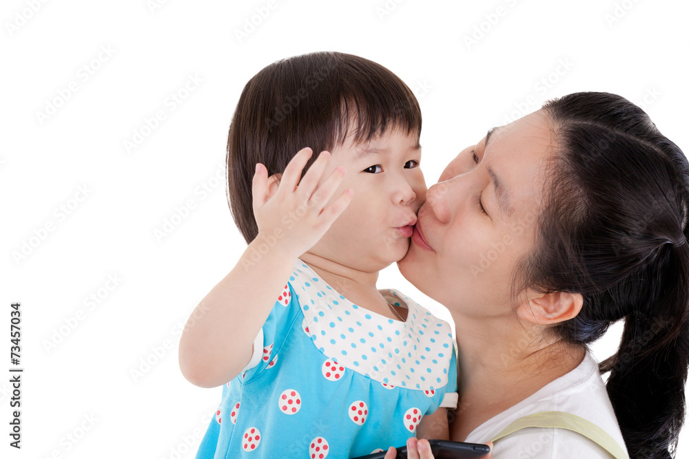 Asian mother carrying and smooching her daughter on white backgr Asian mother carrying and smooching her daughter on white backgr