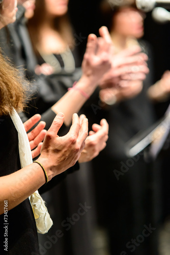 Mani di coriste che battono il tempo musicale, fuoco selettivo