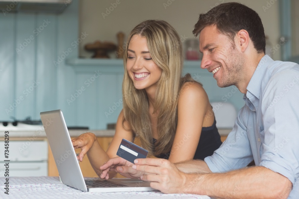 Cute couple using laptop together to shop online Cute couple using laptop together to shop online