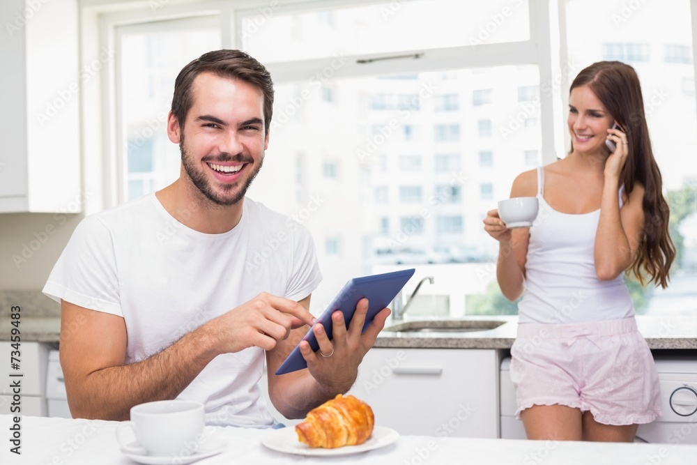 Young man using tablet pc at breakfast Young man using tablet pc at breakfast