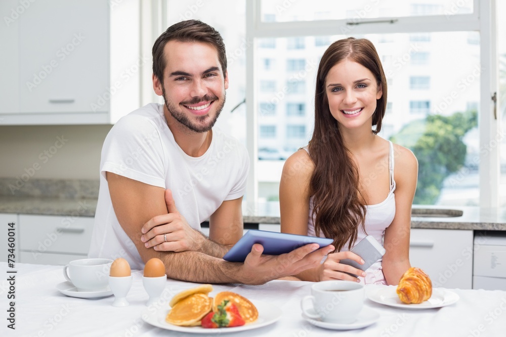 Young couple using tablet at breakfast Young couple using tablet at breakfast