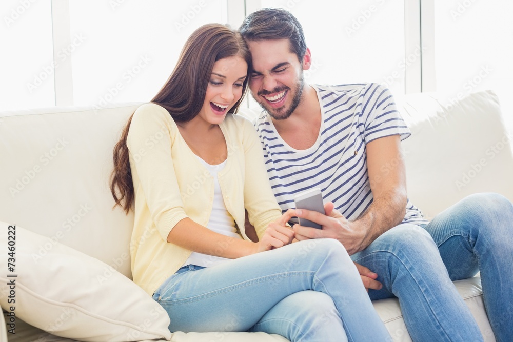 Cute couple relaxing on couch with smartphone Cute couple relaxing on couch with smartphone