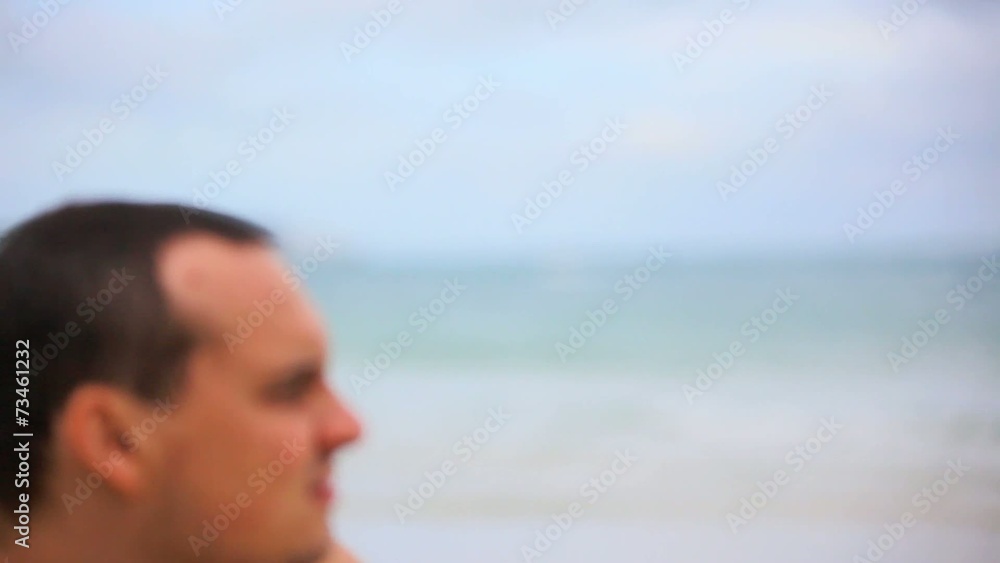Mysterious man sitting on the beach and looks at sea. Change Mysterious man sitting on the beach and looks at sea. Change