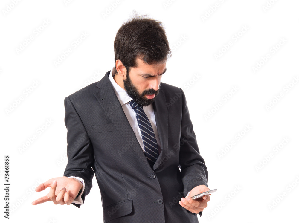 Surprised businessman talking to mobile over white background
