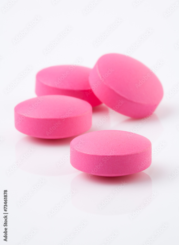 Pink tablet pill on white background Pink tablet pill on white background