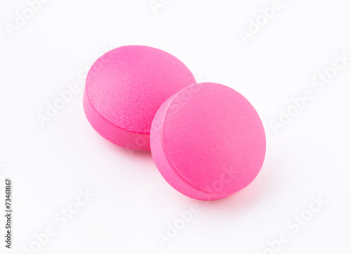Pink tablet pill on white background