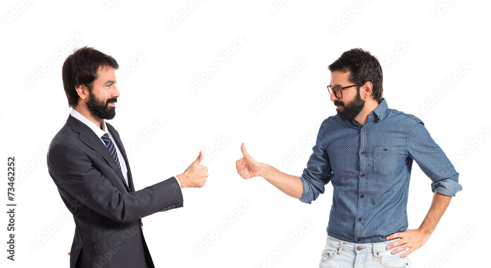 Twin brothers doing victory gesture over white background Twin brothers doing victory gesture over white background