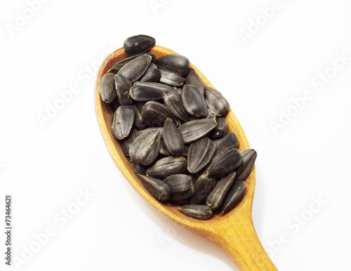 Obraz na płótnie Sunflower seeds on wooden spoon on white background w salonie