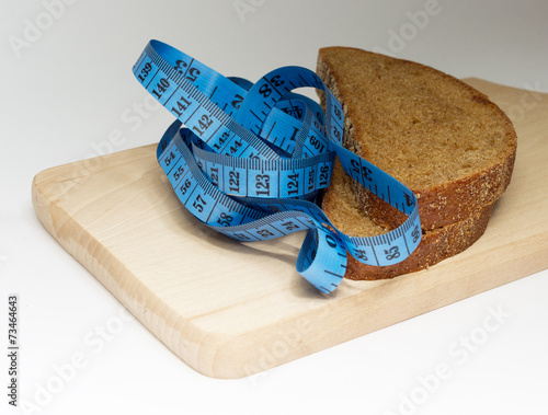Obraz na płótnie Two pieces of dark bread and blue meter on the board w salonie