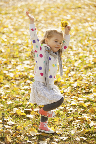 Happy Kid Throwing Autumn Fall Leaves In The Air Outdoor