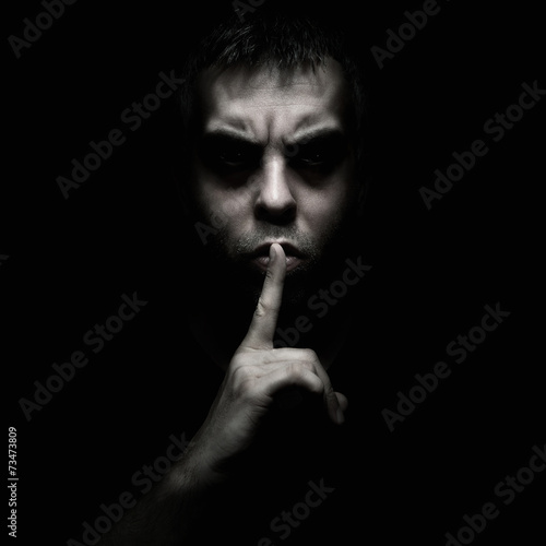 Photography Evil man gesturing silence, quiet isolated on black background