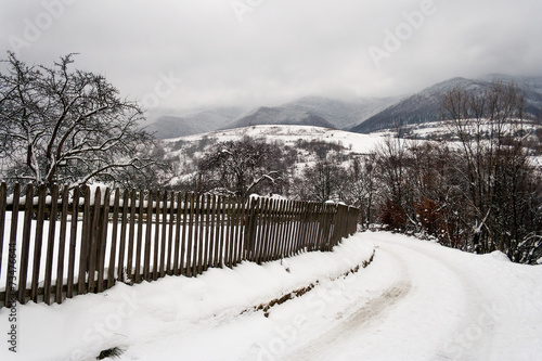 snowy road to village in mountains © Pellinni