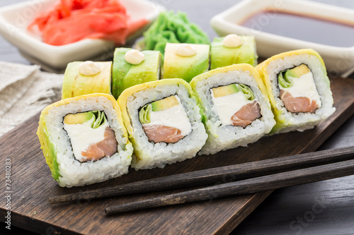 Sushi roll covered with avocado