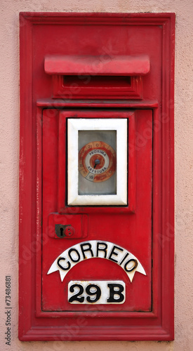 Portuguese red mail box on pink wall.