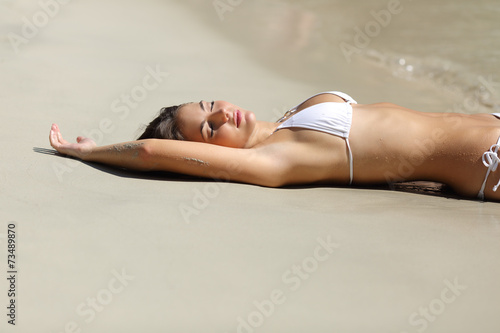 Sunbather woman showing laser hair removal armpit on the beach