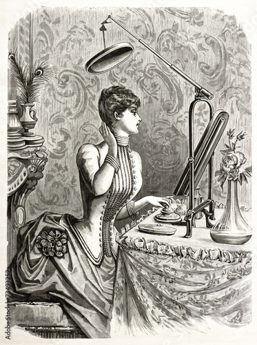 elegant woman looking at mirror. vintage engraving photo