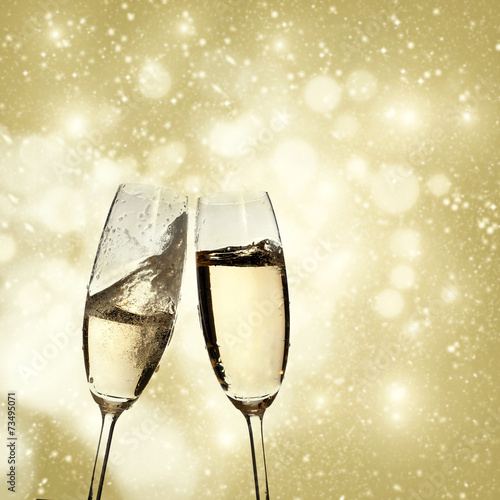 Toasting with champagne glasses on sparkling holiday background