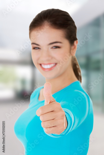 Teen woman gesturing thumbs up