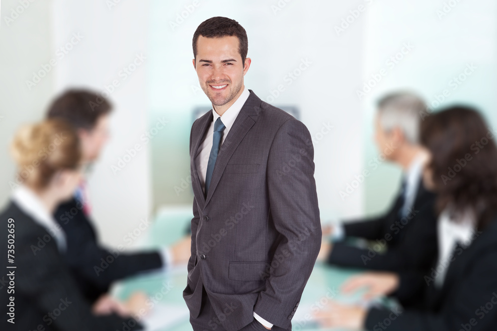 Businessman Standing Against Colleagues In Meeting At Office