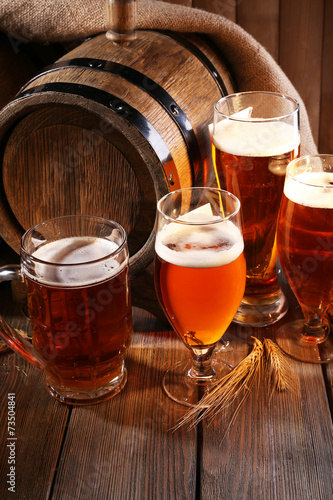 Beer barrel with beer glasses on table on wooden background photo