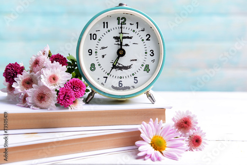 Fototapeta Naklejka Na Ścianę i Meble -  Beautiful flowers with clock and book