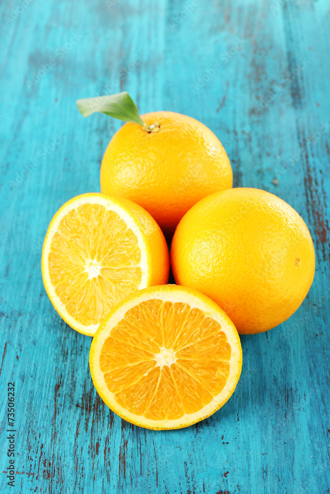 Ripe tangerines and oranges with leaves on wooden background Ripe tangerines and oranges with leaves on wooden background